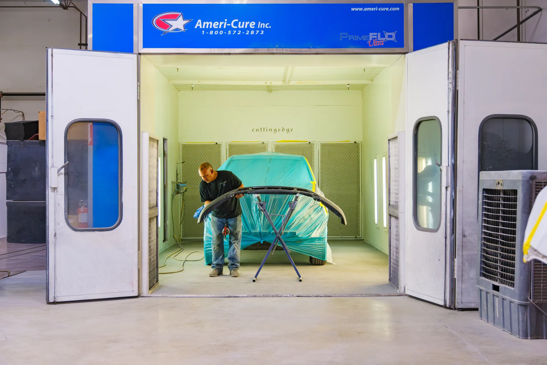 Technician applying finish in paint booth