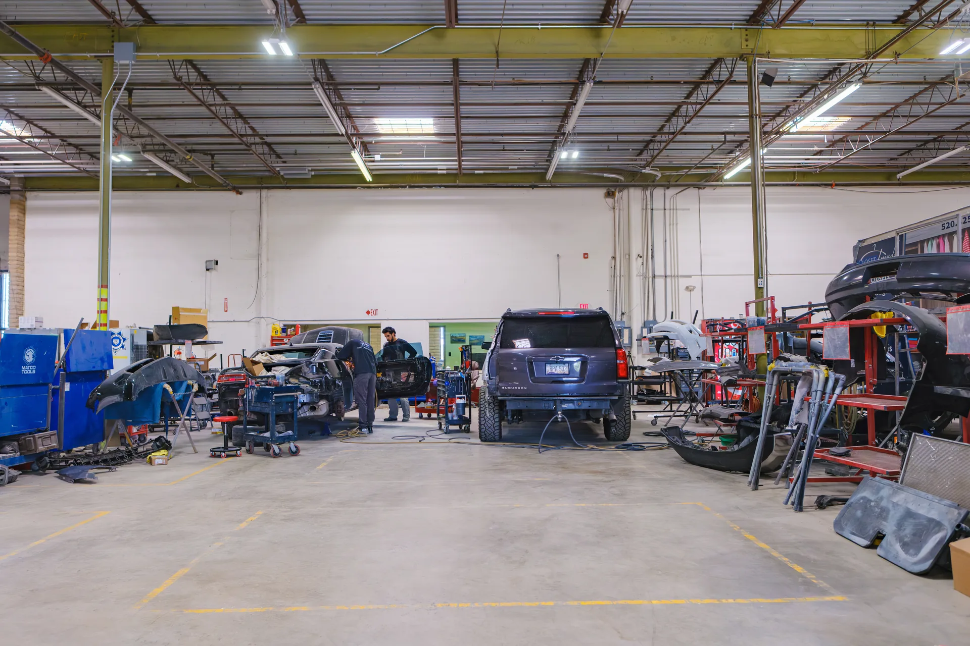 Technician repairing SUV in shop bay